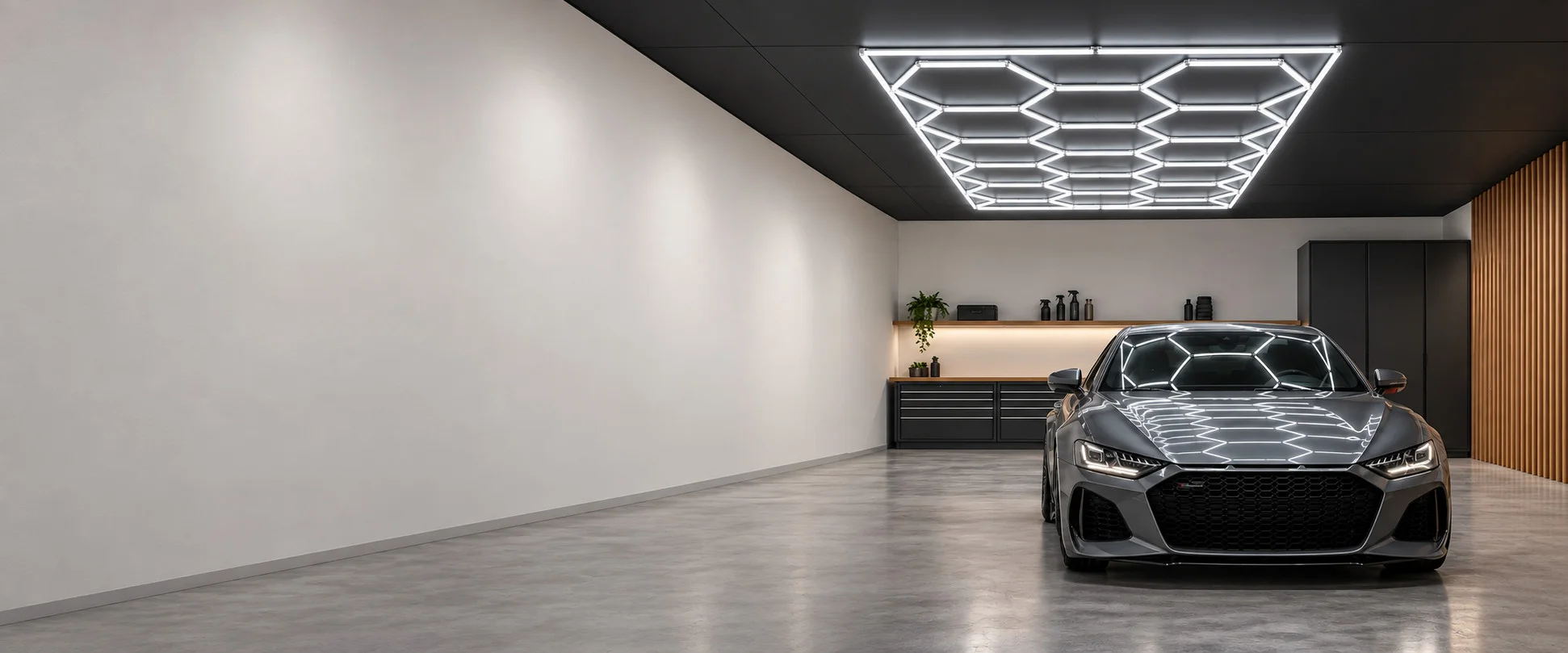Hexagon-Lichtfeld an der Decke einer hellen Garage über einem grauen Sportwagen